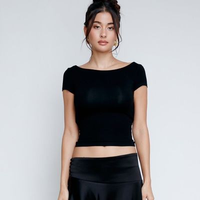 Une femme sexy, mince, sexy, sans dos, courte taille, à manches courtes, en T-shirt.
