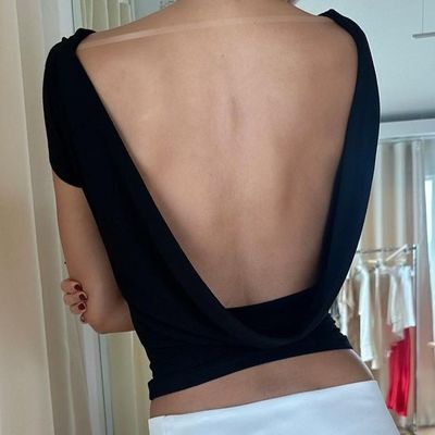 Une femme sexy, mince, sexy, sans dos, courte taille, à manches courtes, en T-shirt.
