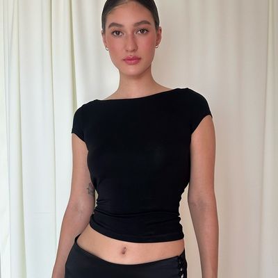 Une femme sexy, mince, sexy, sans dos, courte taille, à manches courtes, en T-shirt.