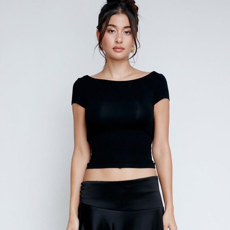 Une femme sexy, mince, sexy, sans dos, courte taille, à manches courtes, en T-shirt.